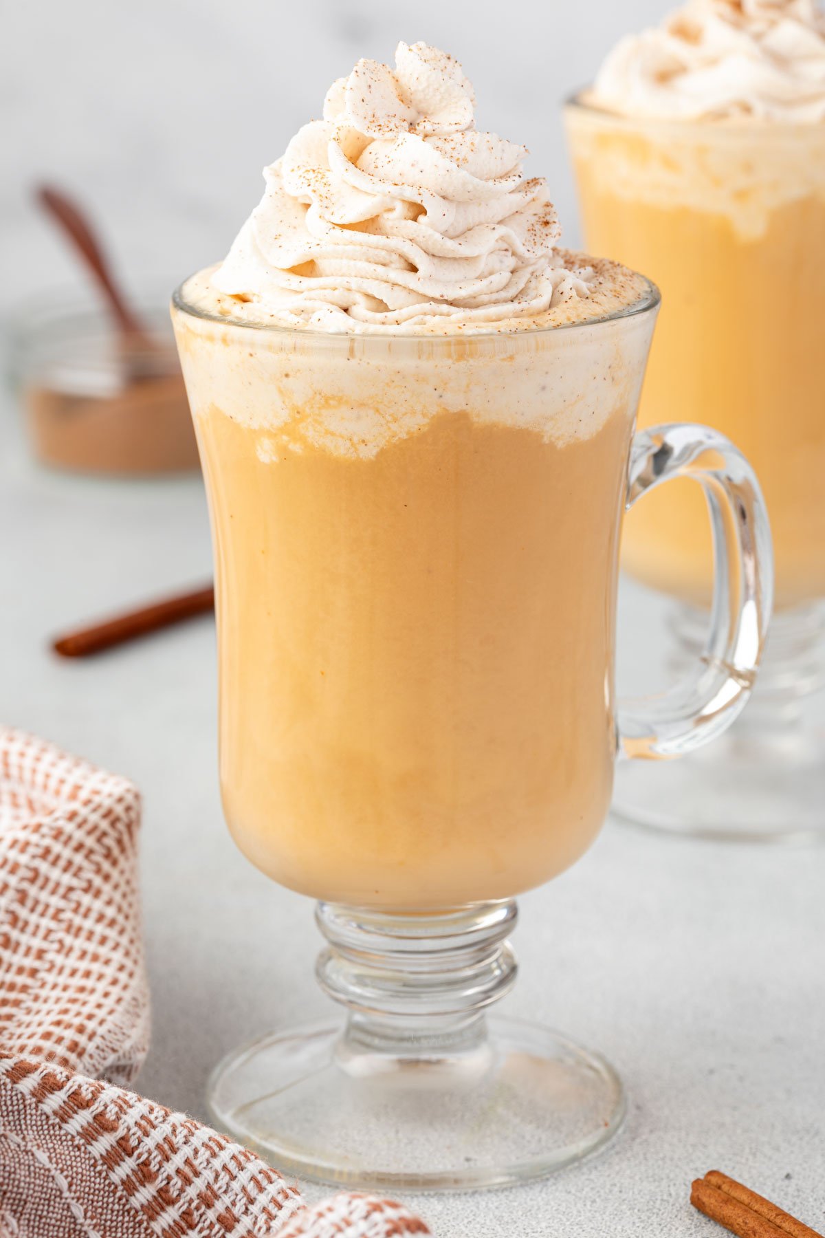 Pumpkin spice latte in a glass mug.