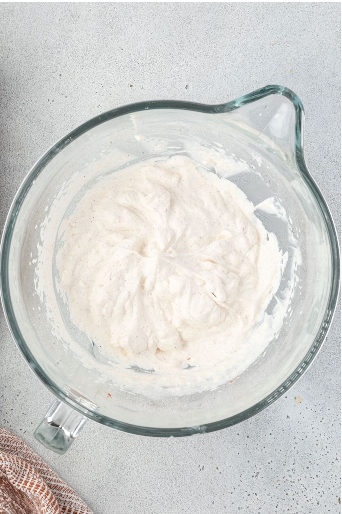 Large mixing bowl with fluffy whipped cream.