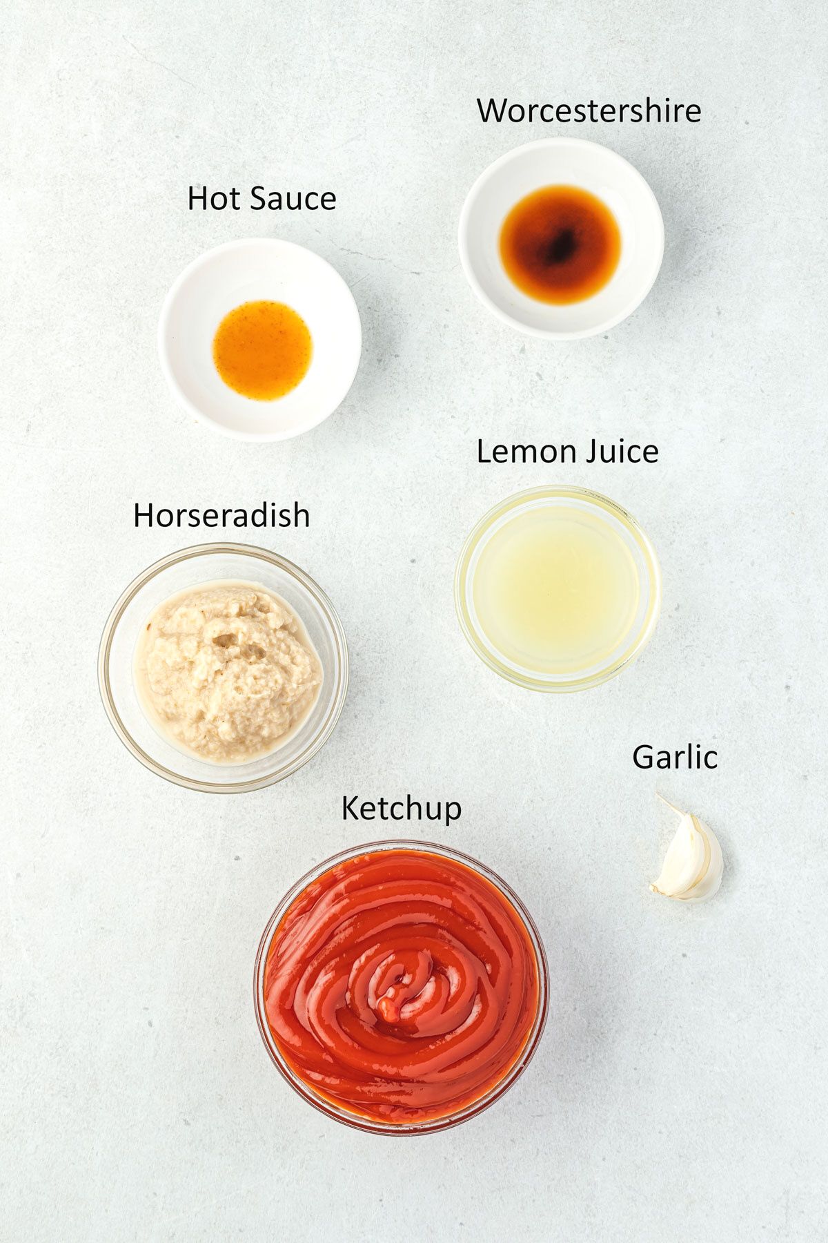 Ingredients for spicy cocktail sauce in individual bowls.