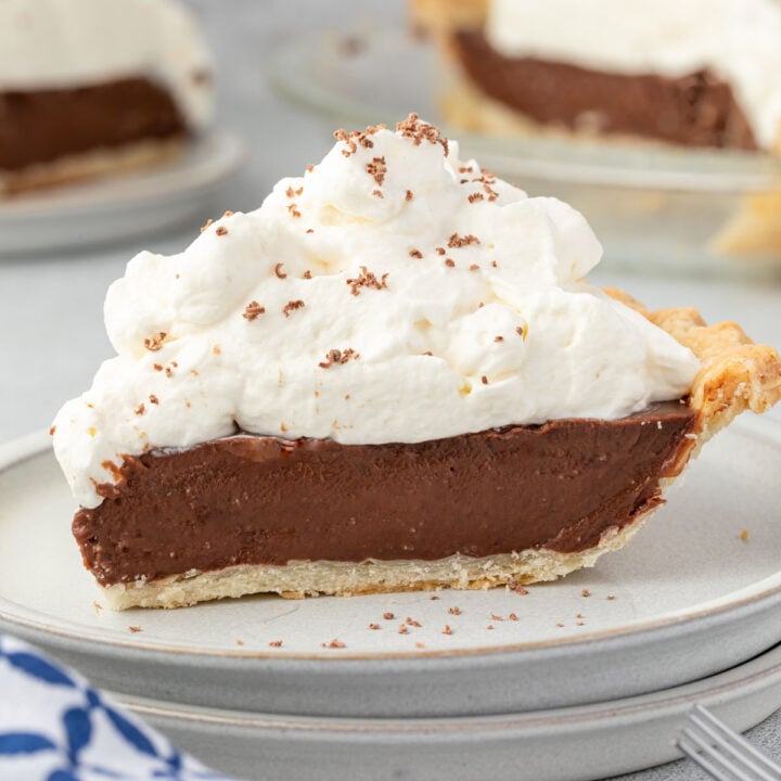 Old fashioned chocolate cream pie with piles of whipped cream and chocolate shavings.