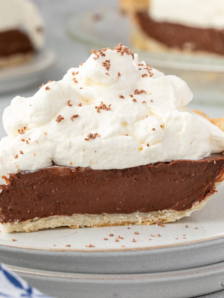 Old fashioned chocolate cream pie with piles of whipped cream and chocolate shavings.