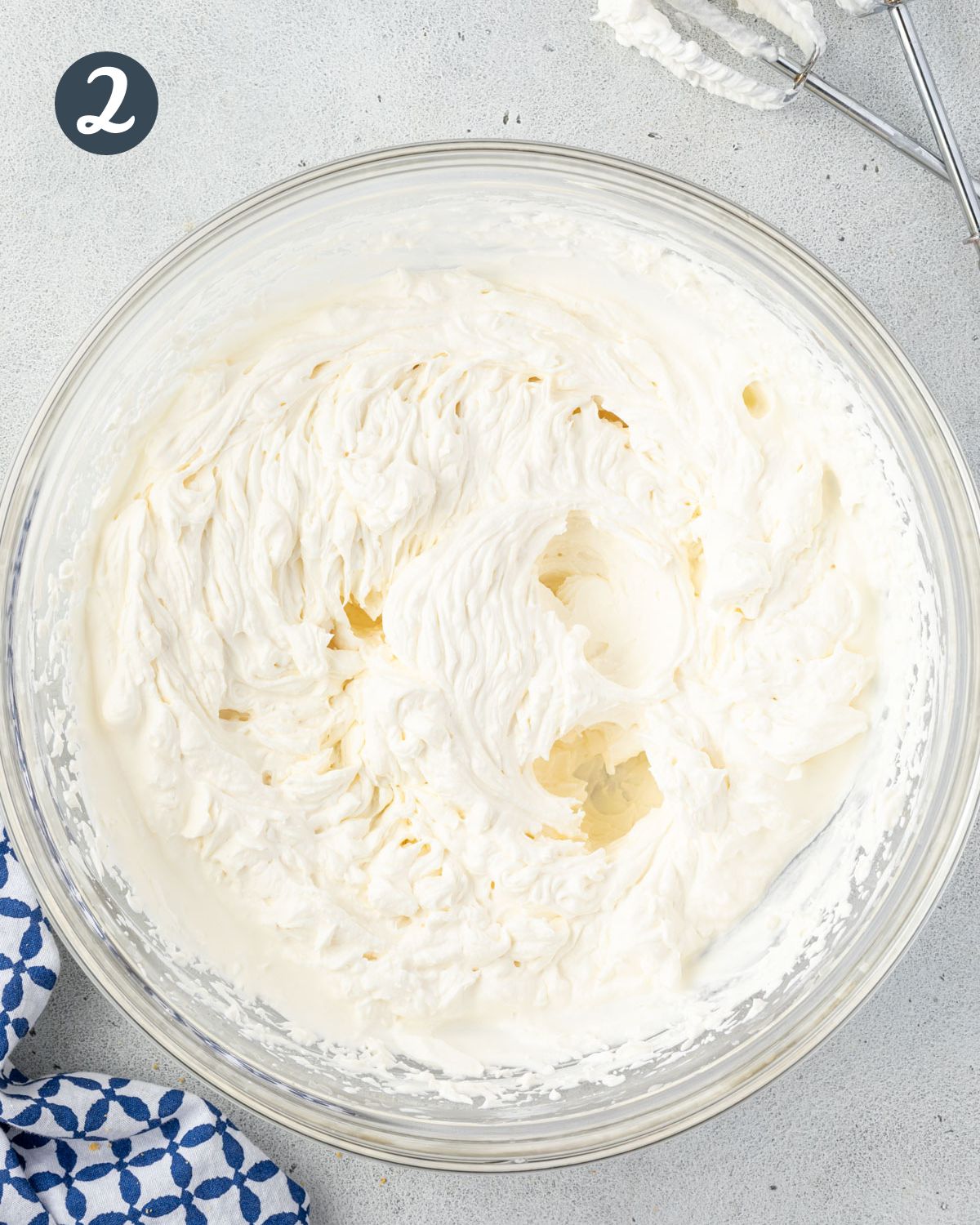 Fluffy whipped cream in a large bowl.