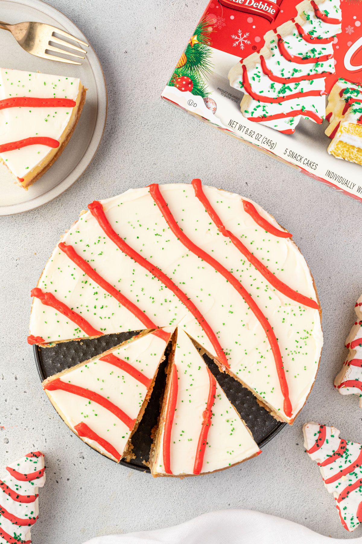 Little Debbie Christmas Tree cheesecake with slices missing, showing red wavy icing lines and green sprinkles to look like the trees.