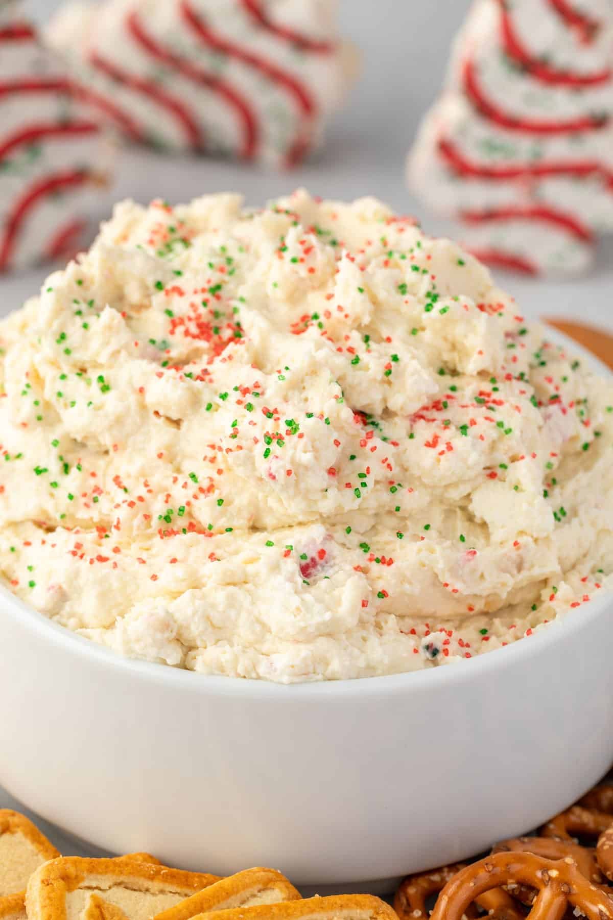 Fluffy Christmas tree cake dip in a white bowl with red and green sprinkles on top.