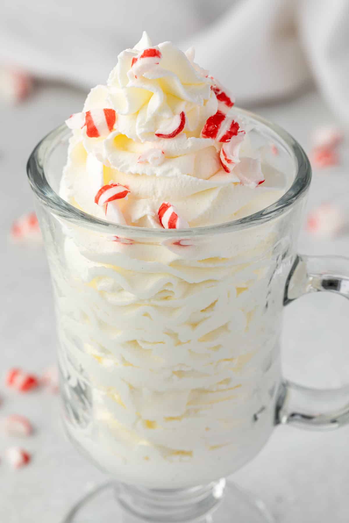 Whipped cream piped into a mug topped with peppermint candies.