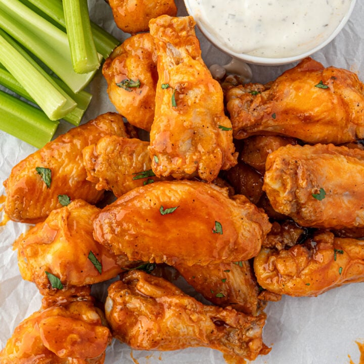 Lots of saucy chicken wings with celery and ranch.