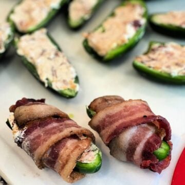A jalapeno that is cut in half, stuffed, and wrapped in bacon.