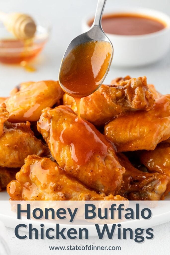 Pinterest pin that says "honey buffalo chicken wings" and has the wings in a pile with sauce dripping from a spoon above it.
