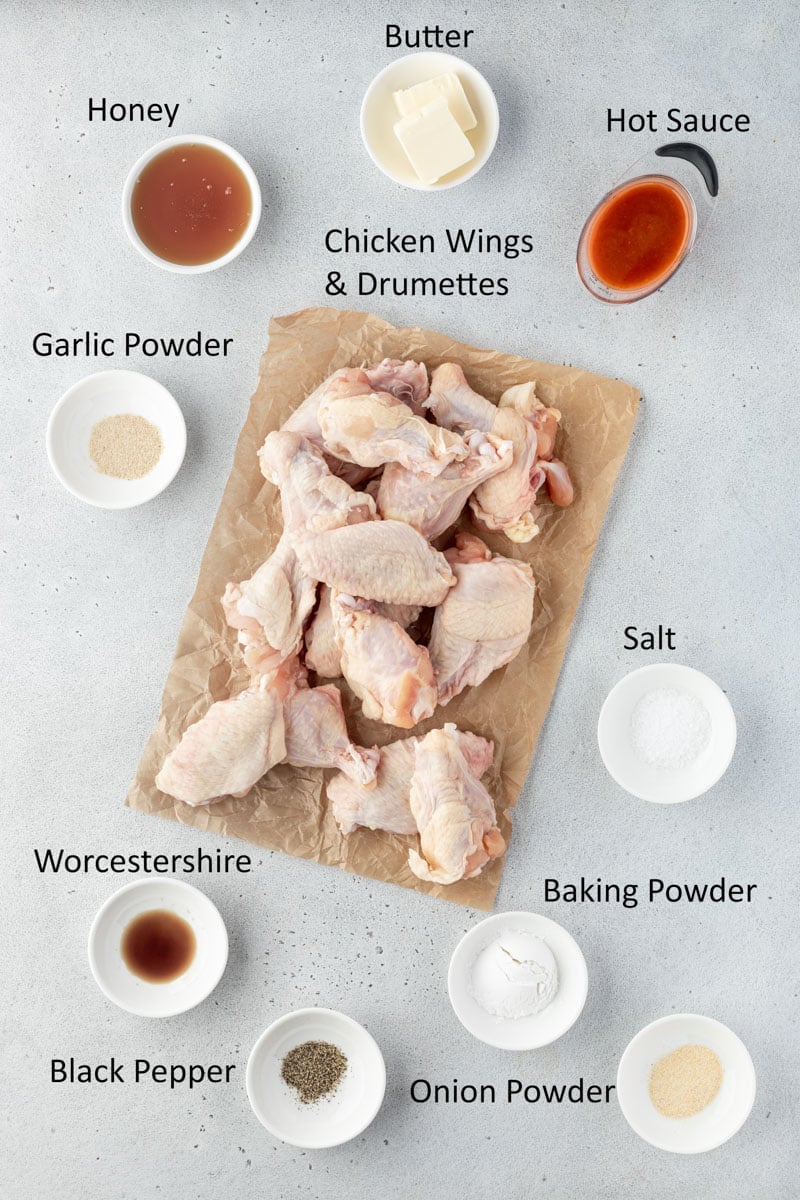 Recipe ingredients in individual bowls with wings on brown parchment.
