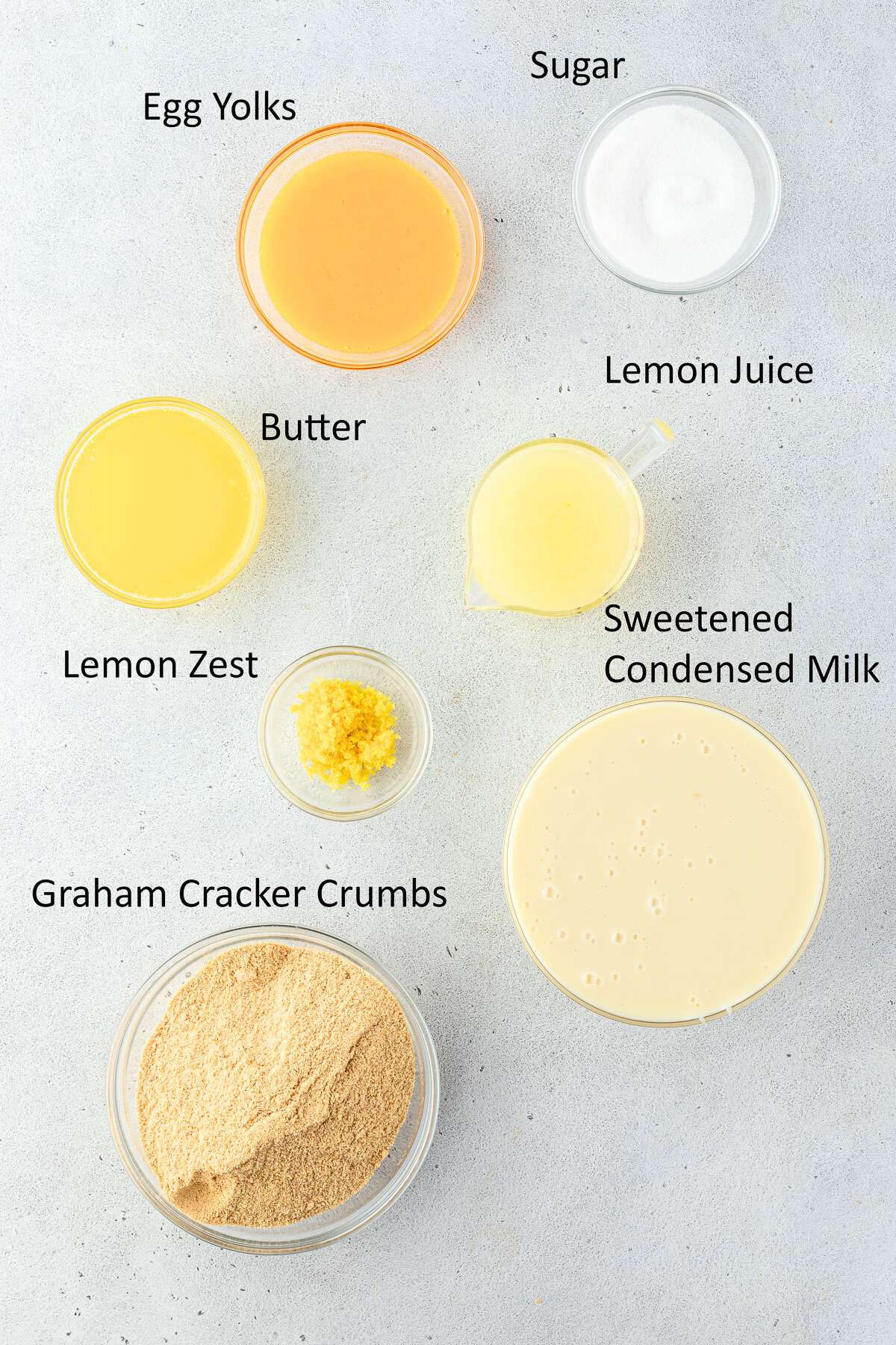 Lemon bar recipe ingredients in indivdual bowls.