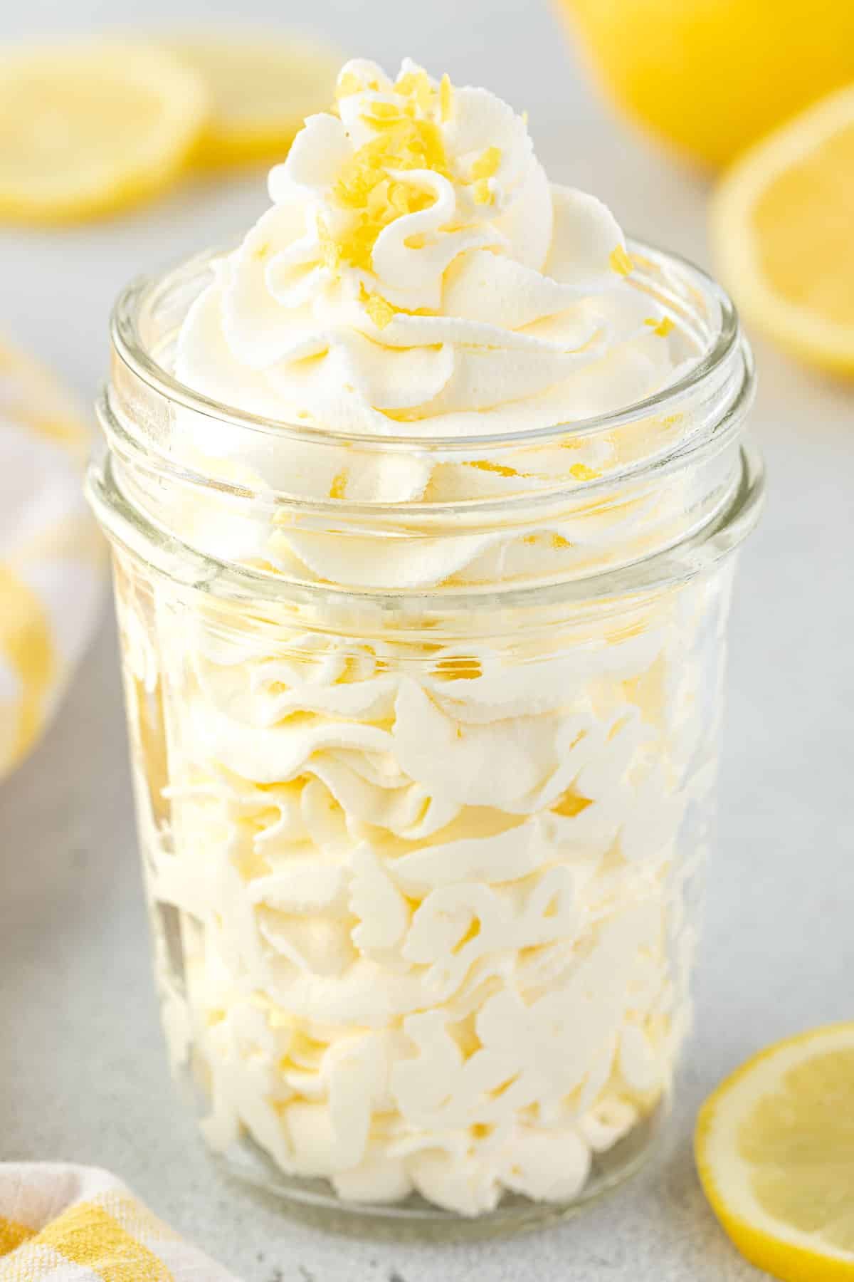 Whipped cream piped in a jar with lemon zest on top.