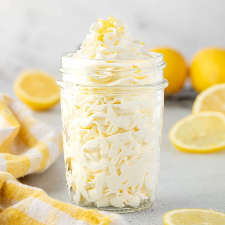 Ruffles of whipped cream layered in a majon jar with lemon zest on top.