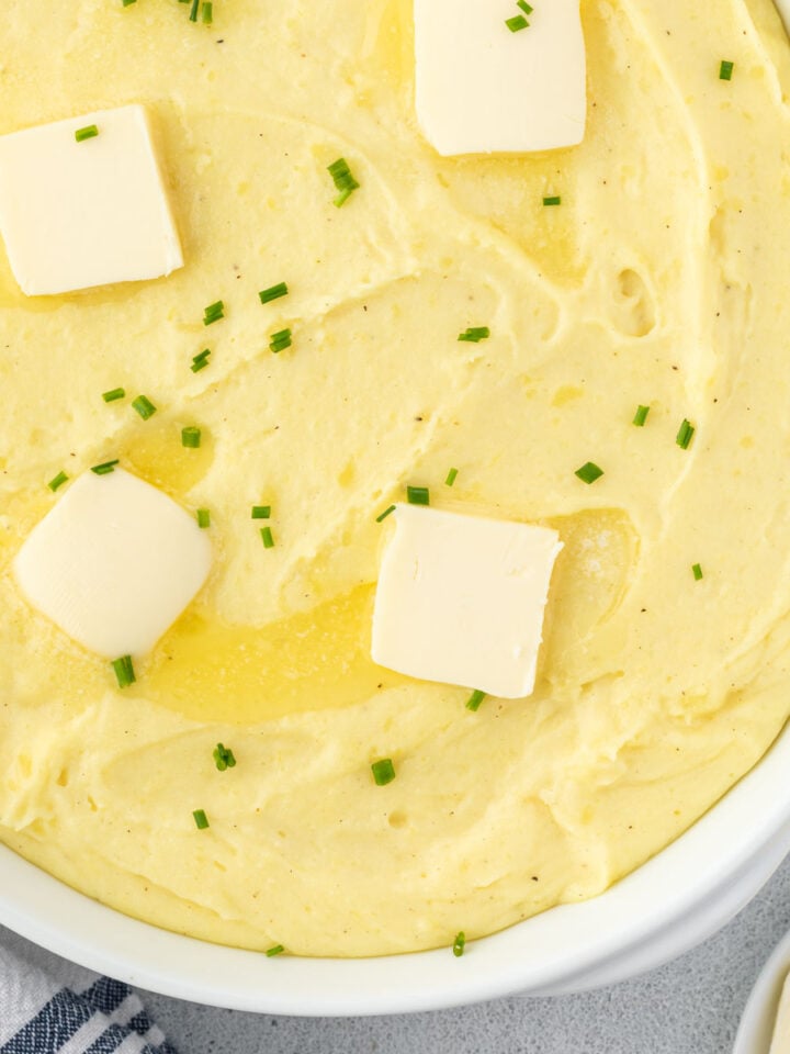 A velvety mashed potatoes recipe in a white oval baking dish.