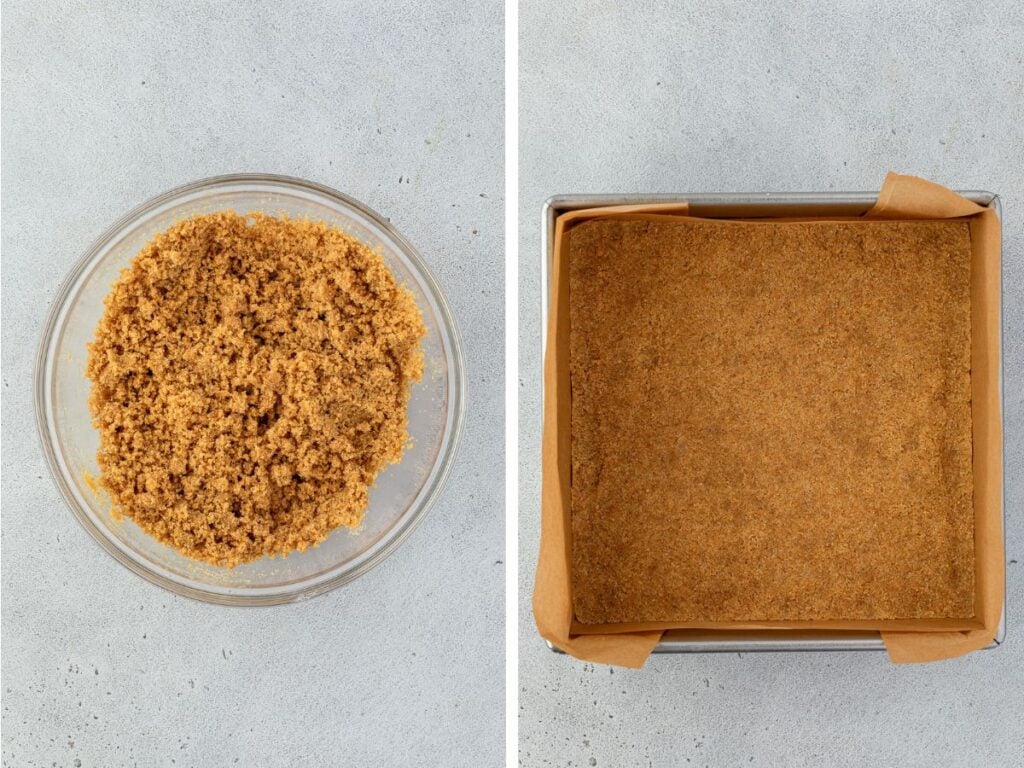 A bowl of crushed graham crackers on the left sits next to a square baking pan with pressed graham cracker crust lined with parchment paper.