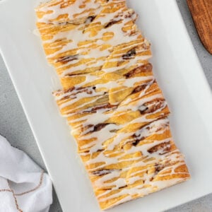 A rectangular glazed pastry on a white plate.