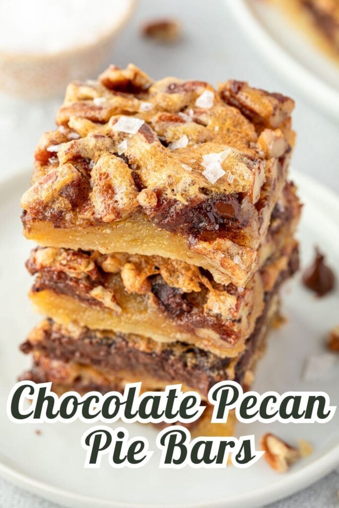 A stack of chocolate pecan pie bars on a plate, topped with flaky sea salt.
