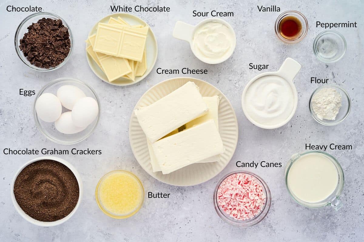Ingredients for a dessert, including cream cheese, eggs, sugar, white chocolate, chocolate, and candy canes.