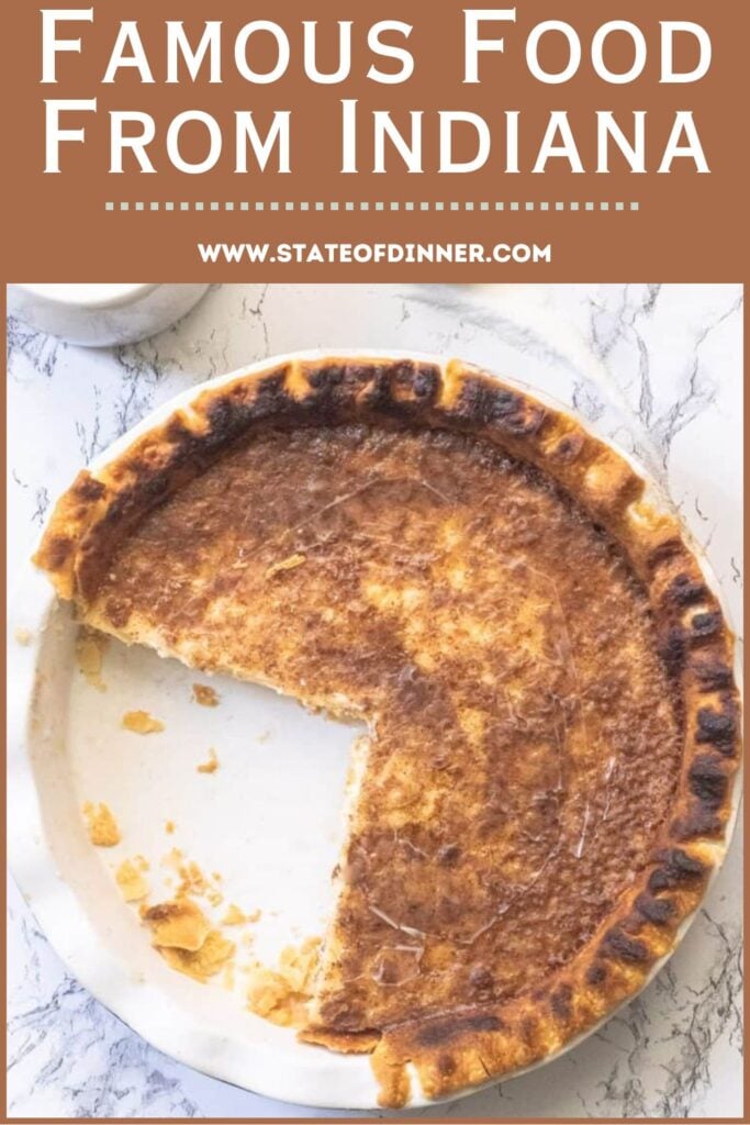 A partially eaten sugar cream pie in a white dish, labeled as famous food from Indiana.