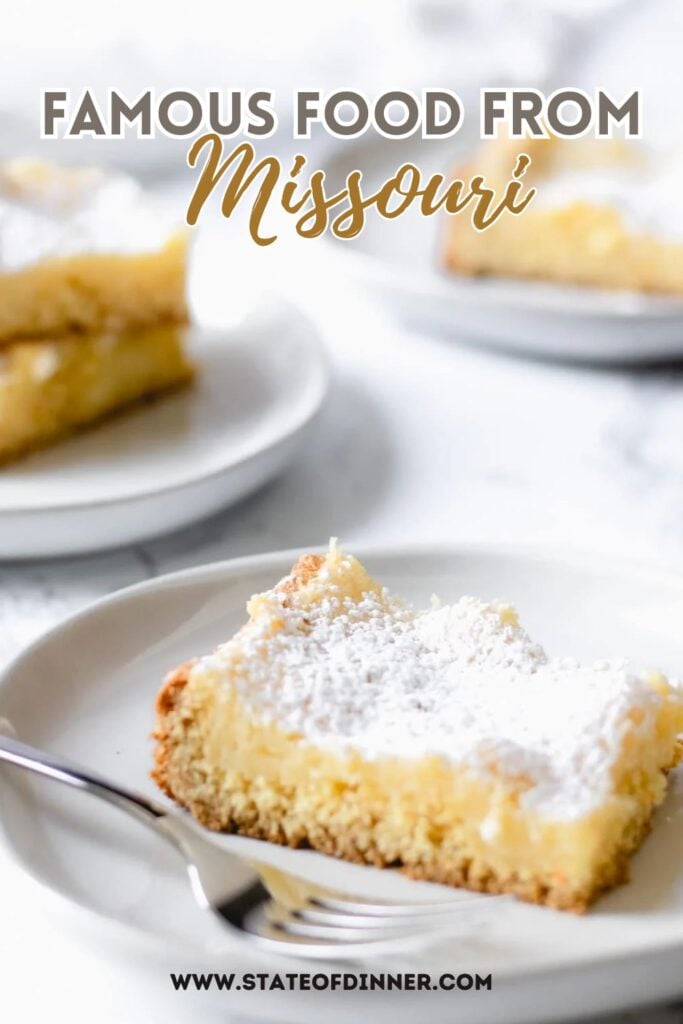 A slice of powdered sugar-topped cake on a plate, labeled "Famous Food from Missouri.