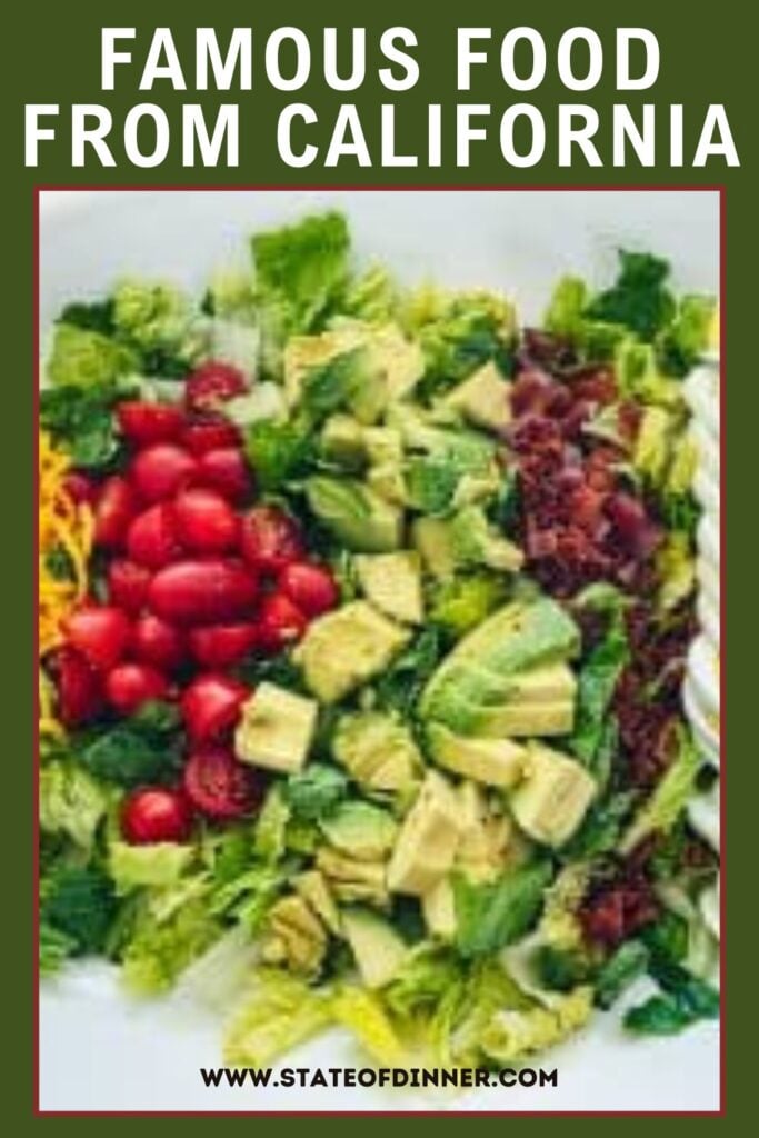 A colorful Cobb salad with avocado, tomatoes, bacon, and lettuce, labeled as famous food from California.