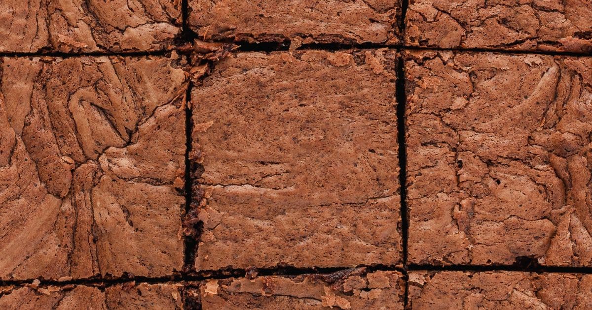 Close-up of sliced chocolate brownies, showing their cracked, textured tops and fudgy centers.