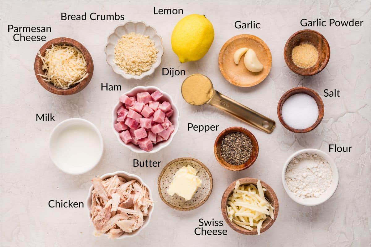 Ingredients for chicken cordon bleu casserole, labeled in bowls and arranged on a light surface.