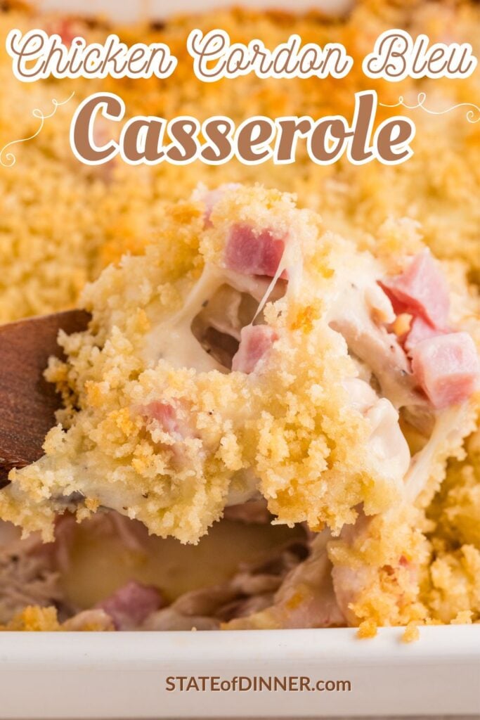 A cheesy chicken cordon bleu casserole topped with breadcrumbs and diced ham being served with a wooden spoon.