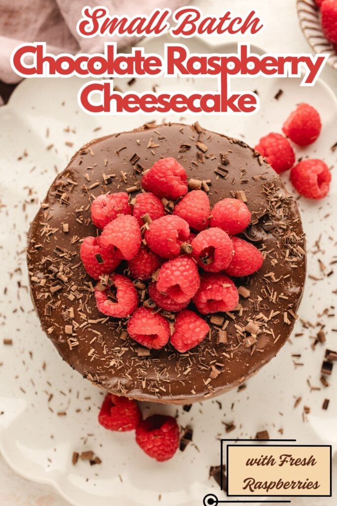 Top-down view of a chocolate cheesecake topped with fresh raspberries and chocolate shavings on a white plate.