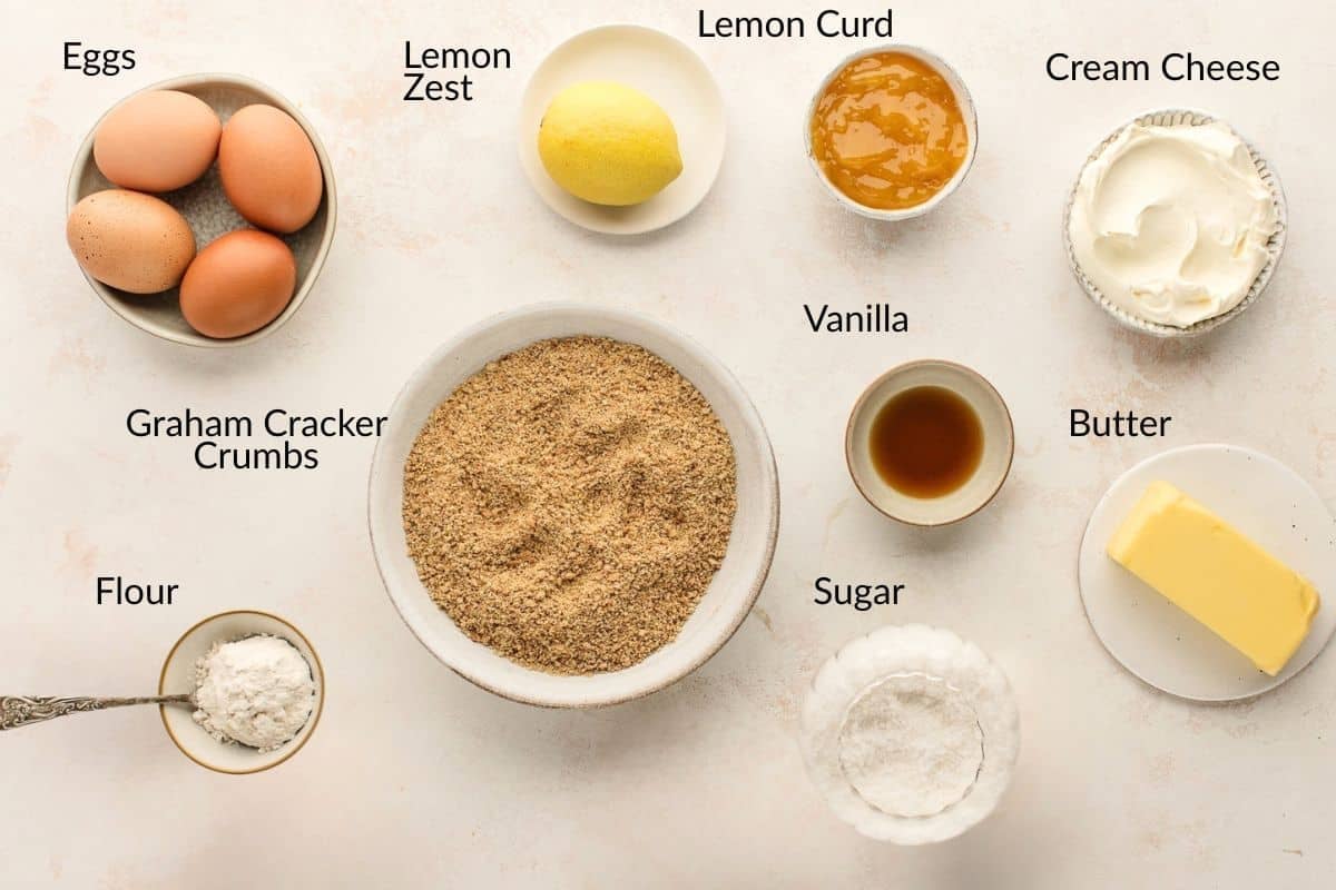 Baking ingredients including eggs, lemon, lemon curd, cream cheese, graham crumbs, vanilla, butter, sugar, and flour.