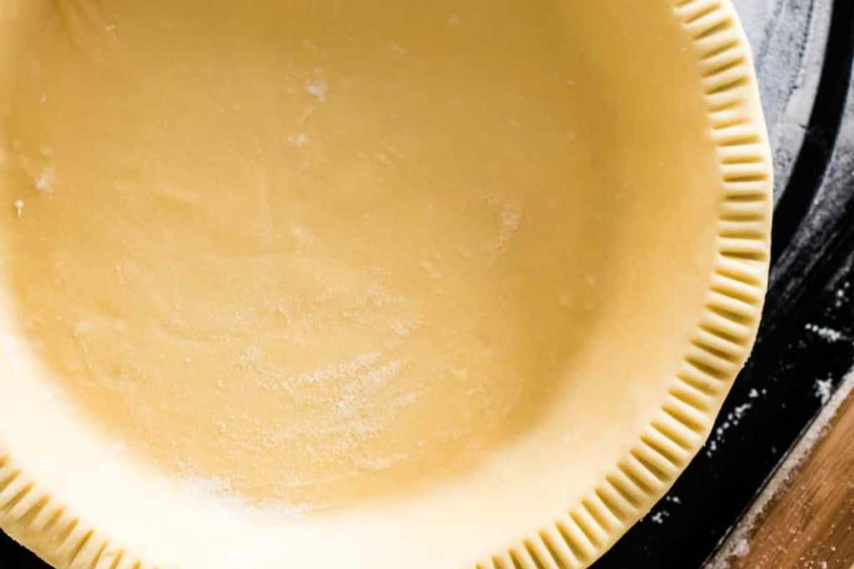 Unbaked pie crust with crimped edges in a pie dish, ready for filling.