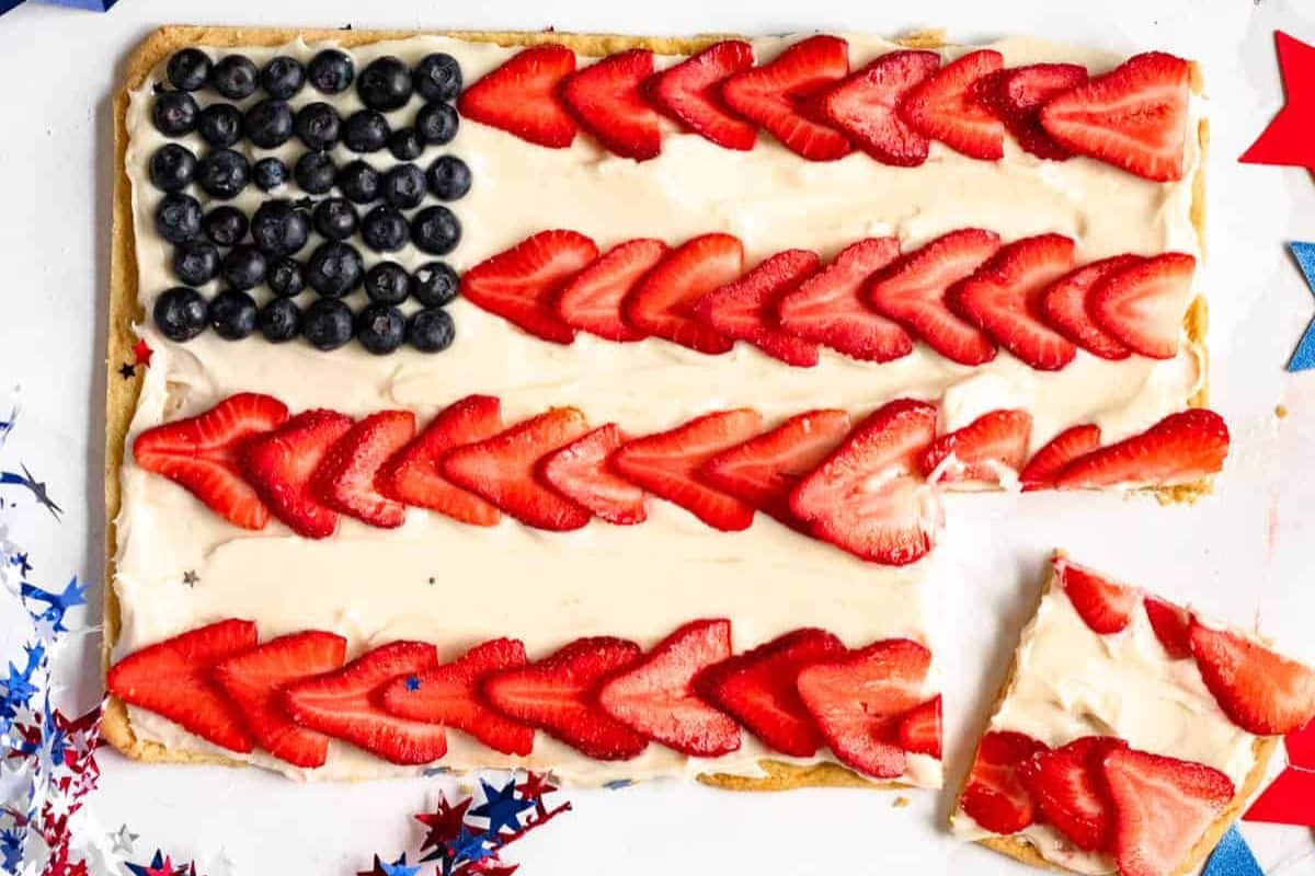 Rectangular dessert decorated with blueberries and sliced strawberries to look like the American flag.