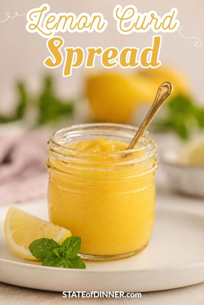 A jar of lemon curd spread with a spoon, garnished with a lemon slice and mint on a white plate.