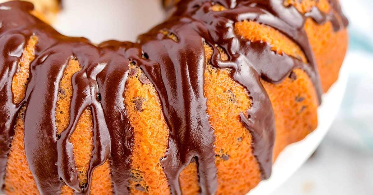 Close-up of a bundt cake drizzled with glossy chocolate glaze.
