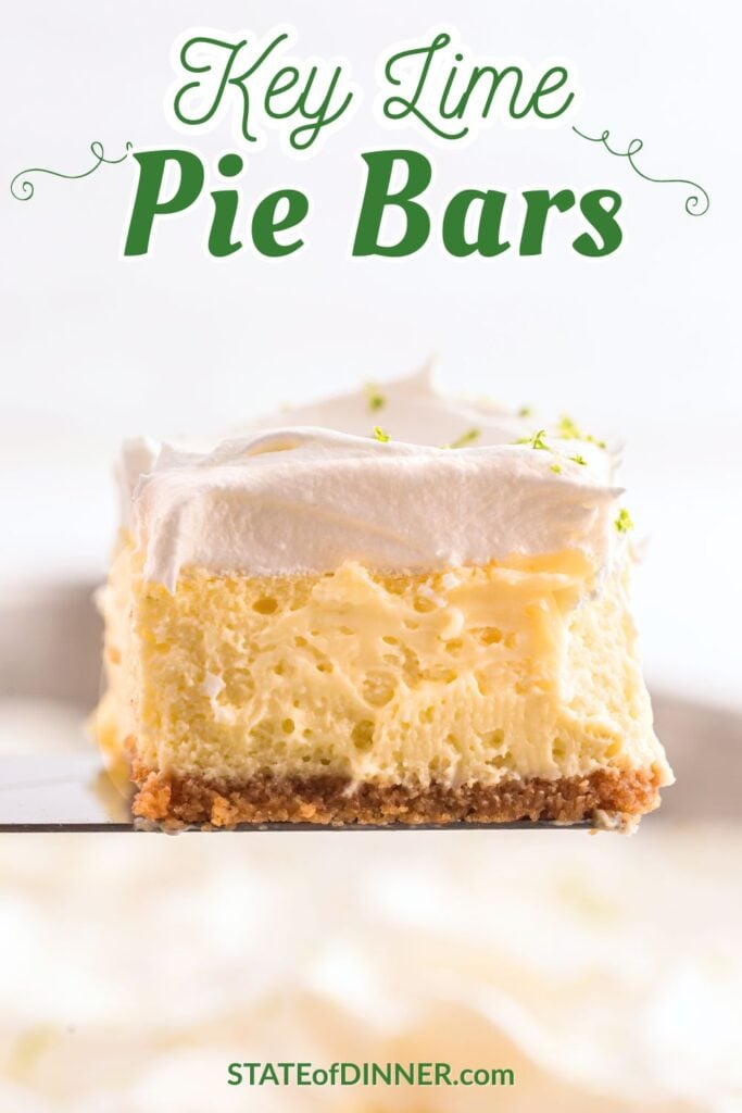 A close-up of a key lime pie bar with a graham cracker crust, creamy filling, and whipped topping.
