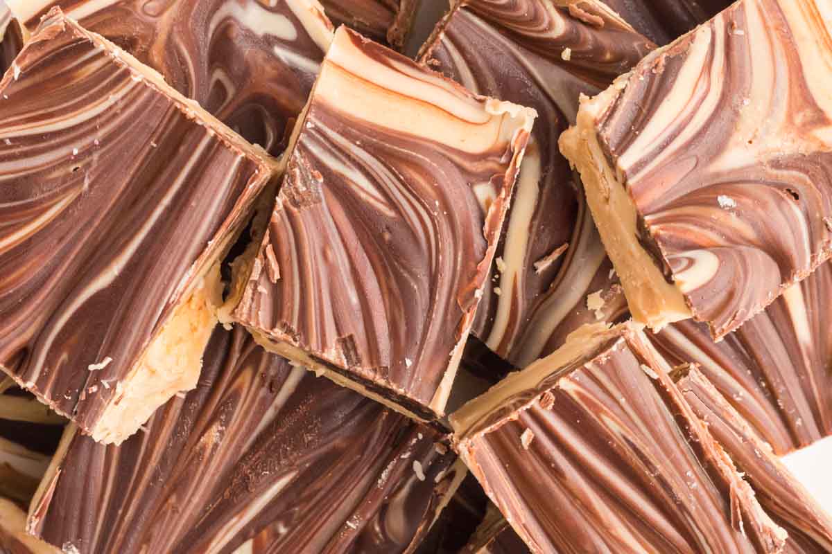 Close-up of several pieces of swirled chocolate and vanilla fudge stacked on top of each other.