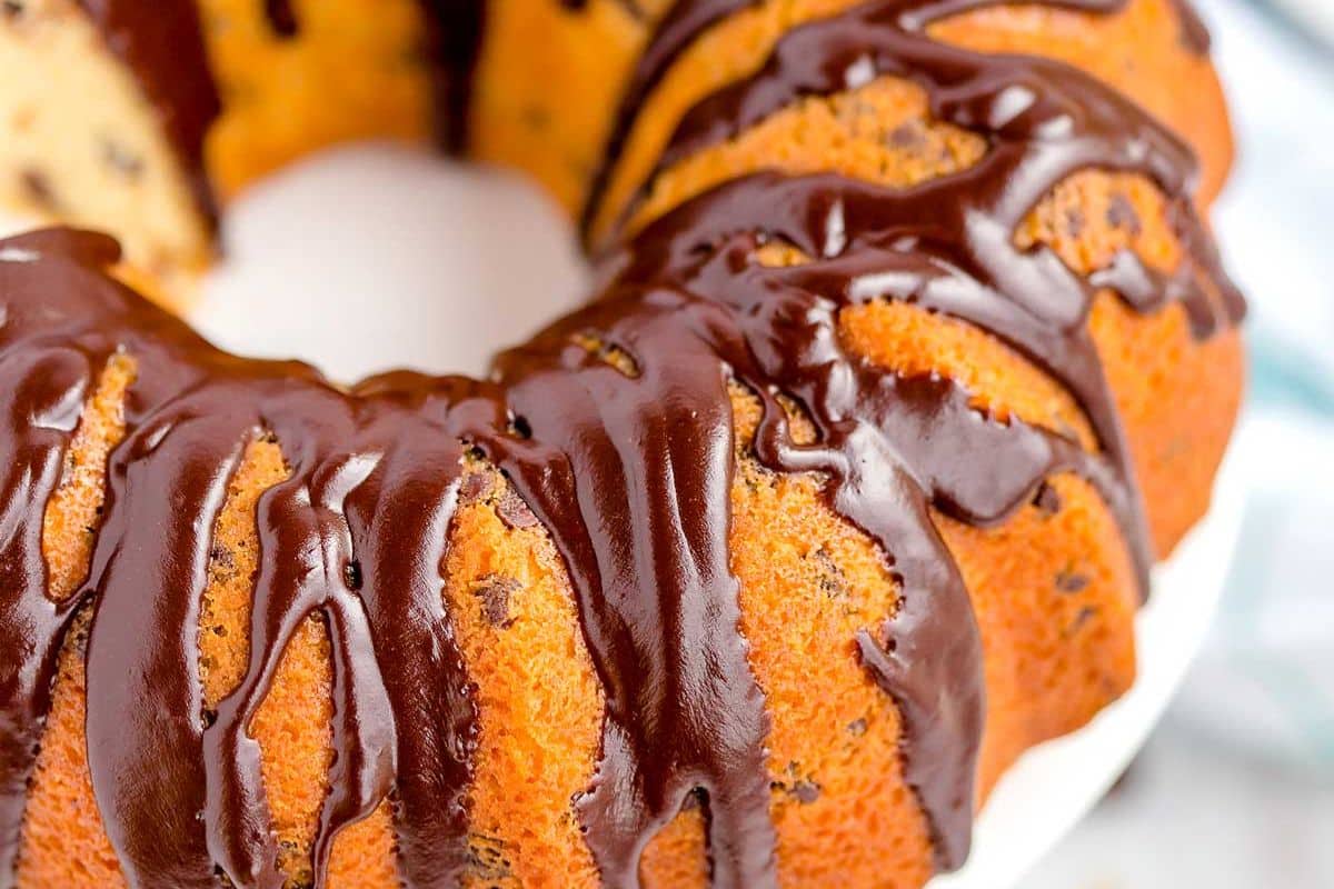Close-up of a bundt cake with chocolate glaze drizzled on top.