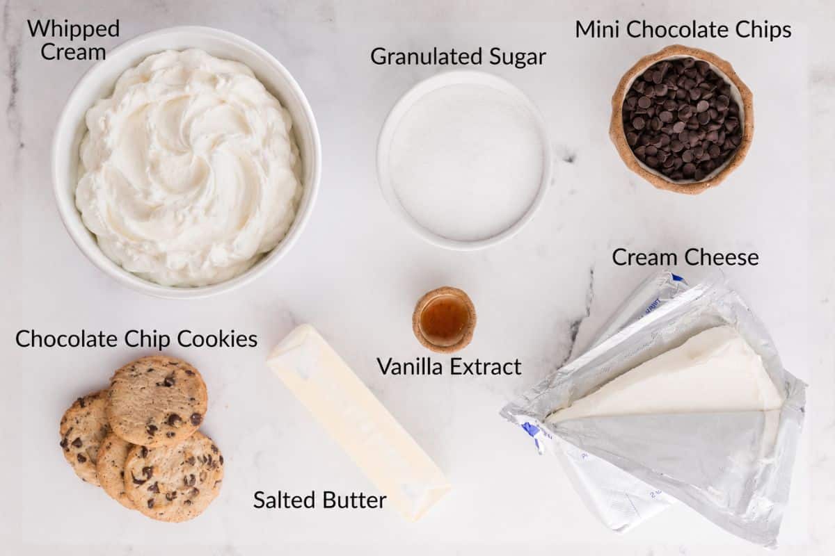 Bowls of whipped cream, granulated sugar, mini chocolate chips, cream cheese, cookies, butter, and vanilla extract.