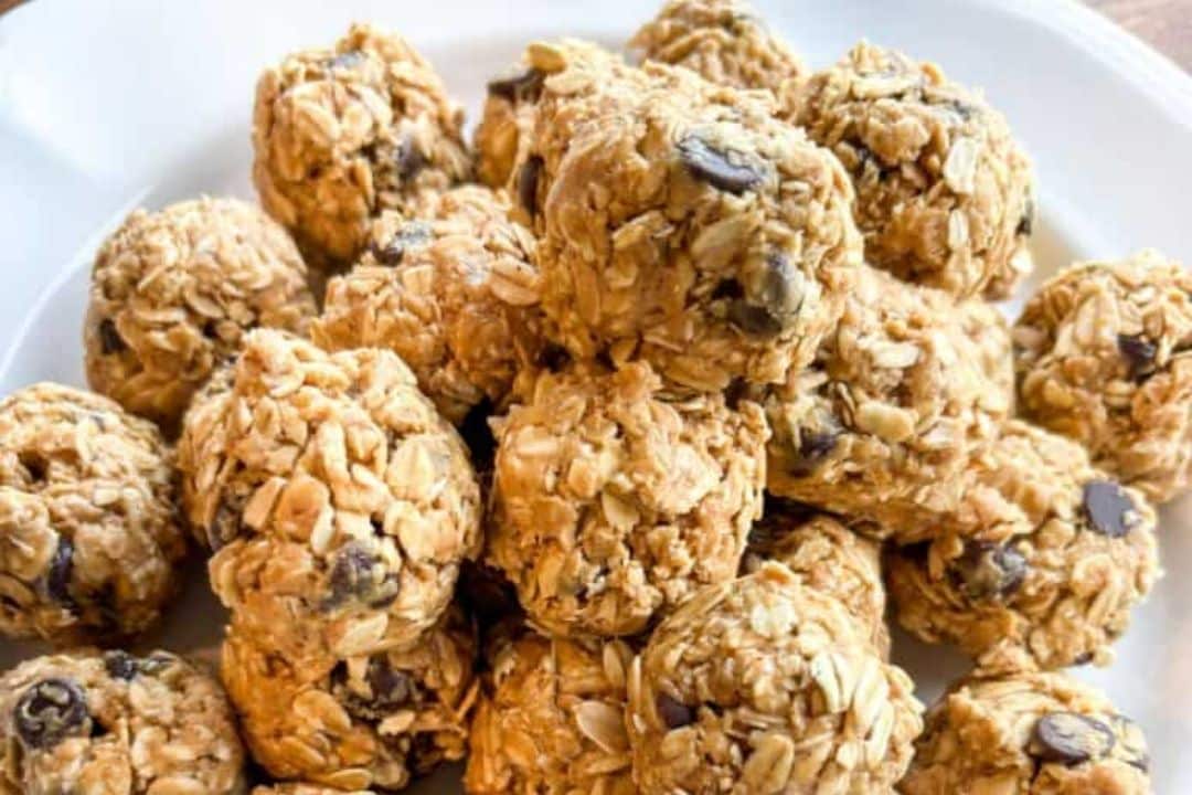 A plate of round oatmeal energy bites with chocolate chips, stacked and ready to eat.