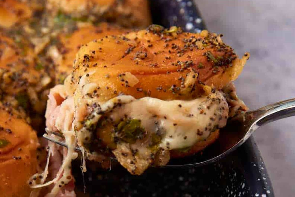 A close up shot of ham and cheese sliders.
