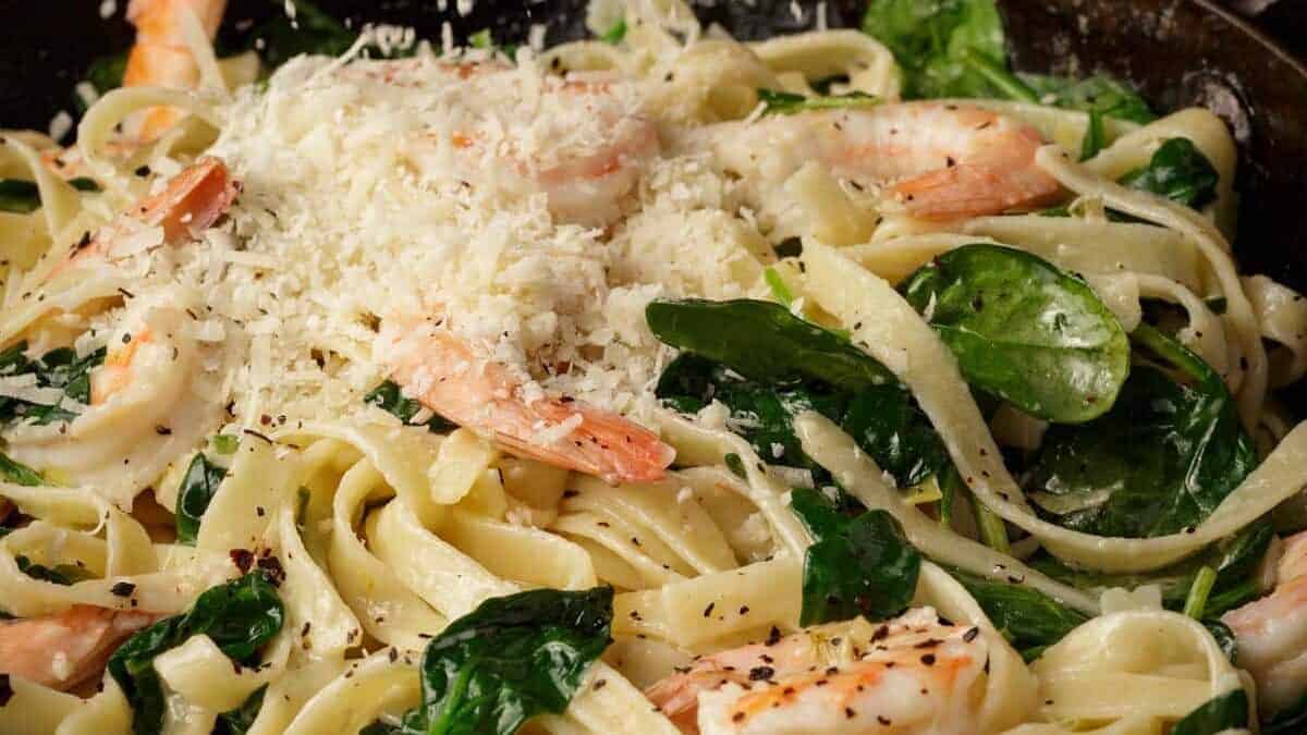 A close up shot of shrimp and spinach pasta.