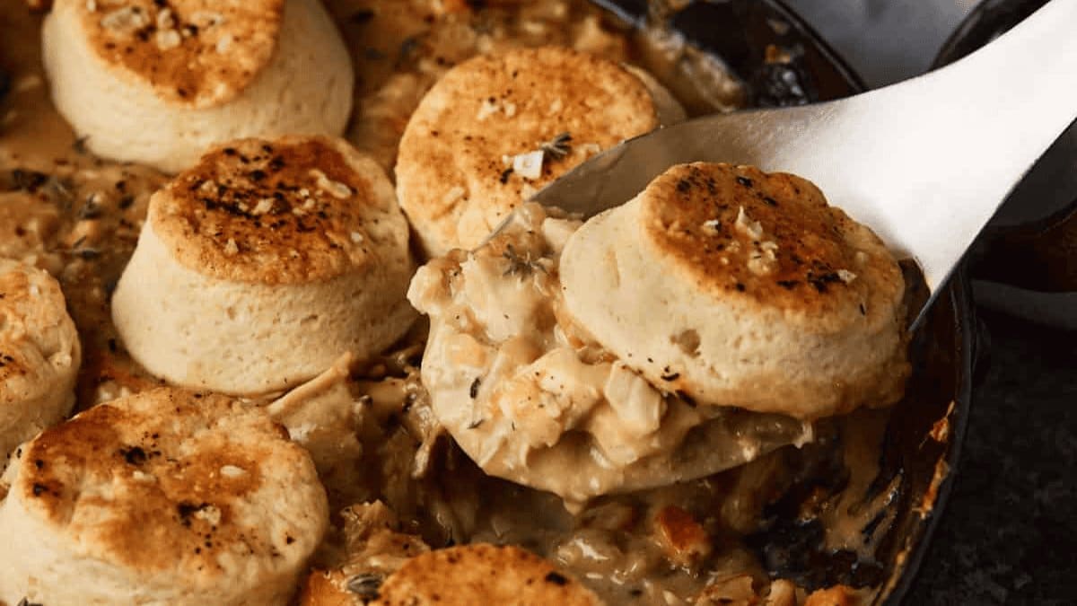 A close up shot of chicken and biscuits.