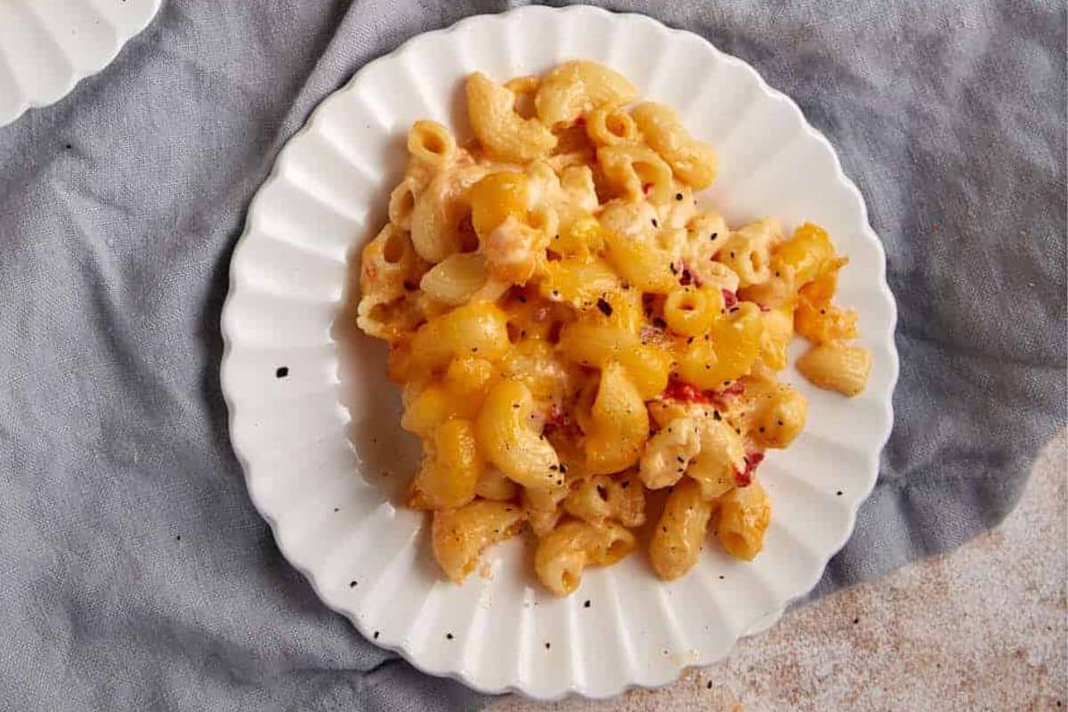 A close up shot of baked mac and cheese with pimientos.