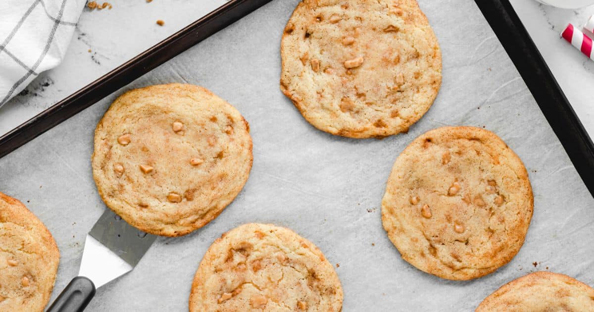 Several freshly baked cookies on a parchment-lined baking sheet.