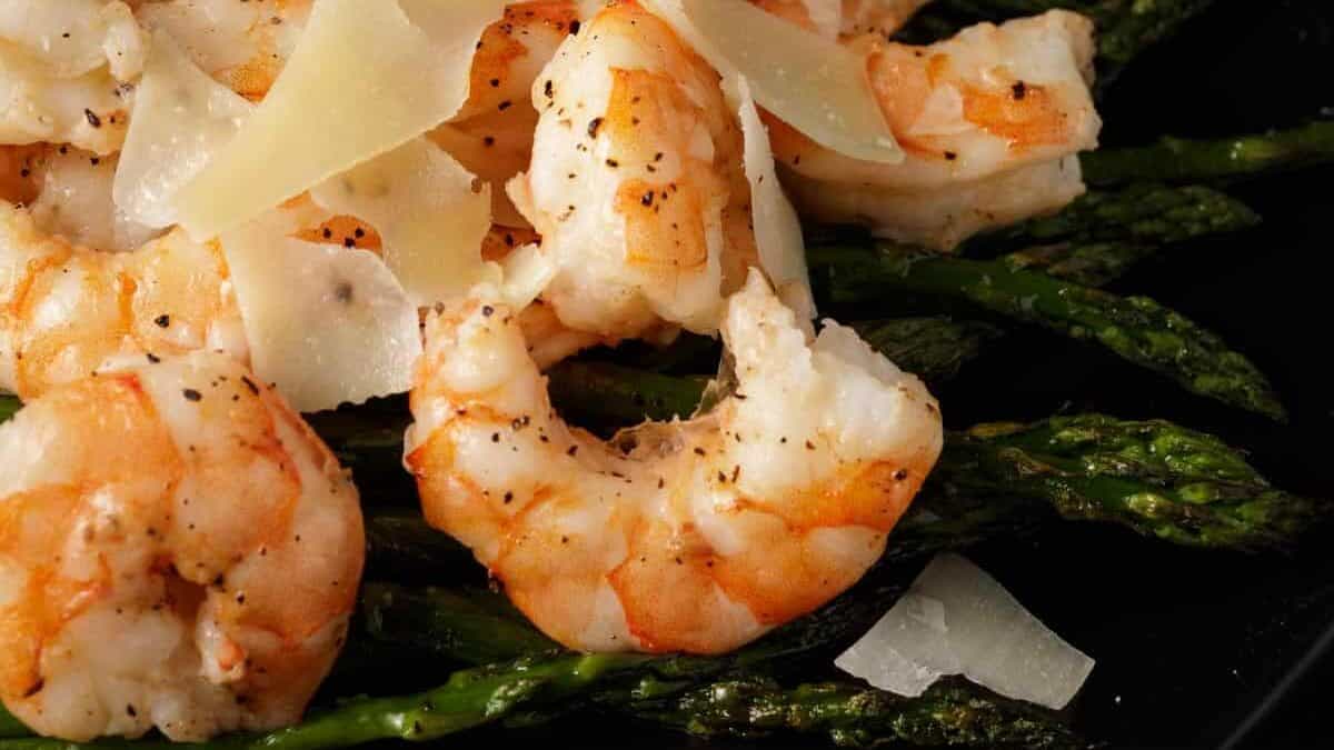Grilled shrimp topped with shaved parmesan cheese served over asparagus.
