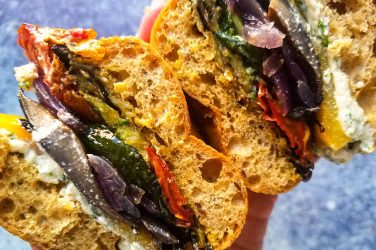 A close up shot of roasted veggie sandwich with pesto.