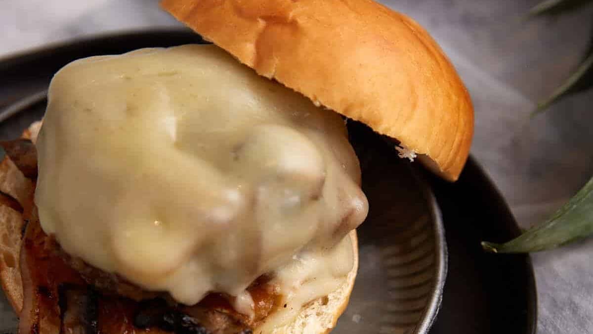 A close up shot of pineapple burgers with provolone.