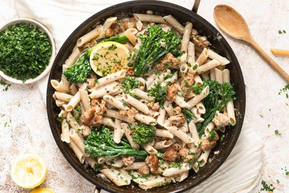 A close up shot of sausage and broccolini.