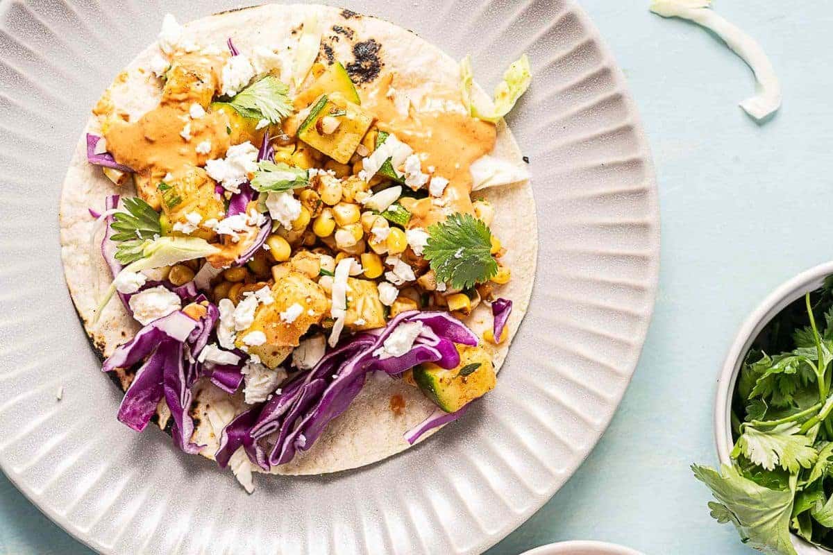 A close up shot of zucchini and corn tacos.